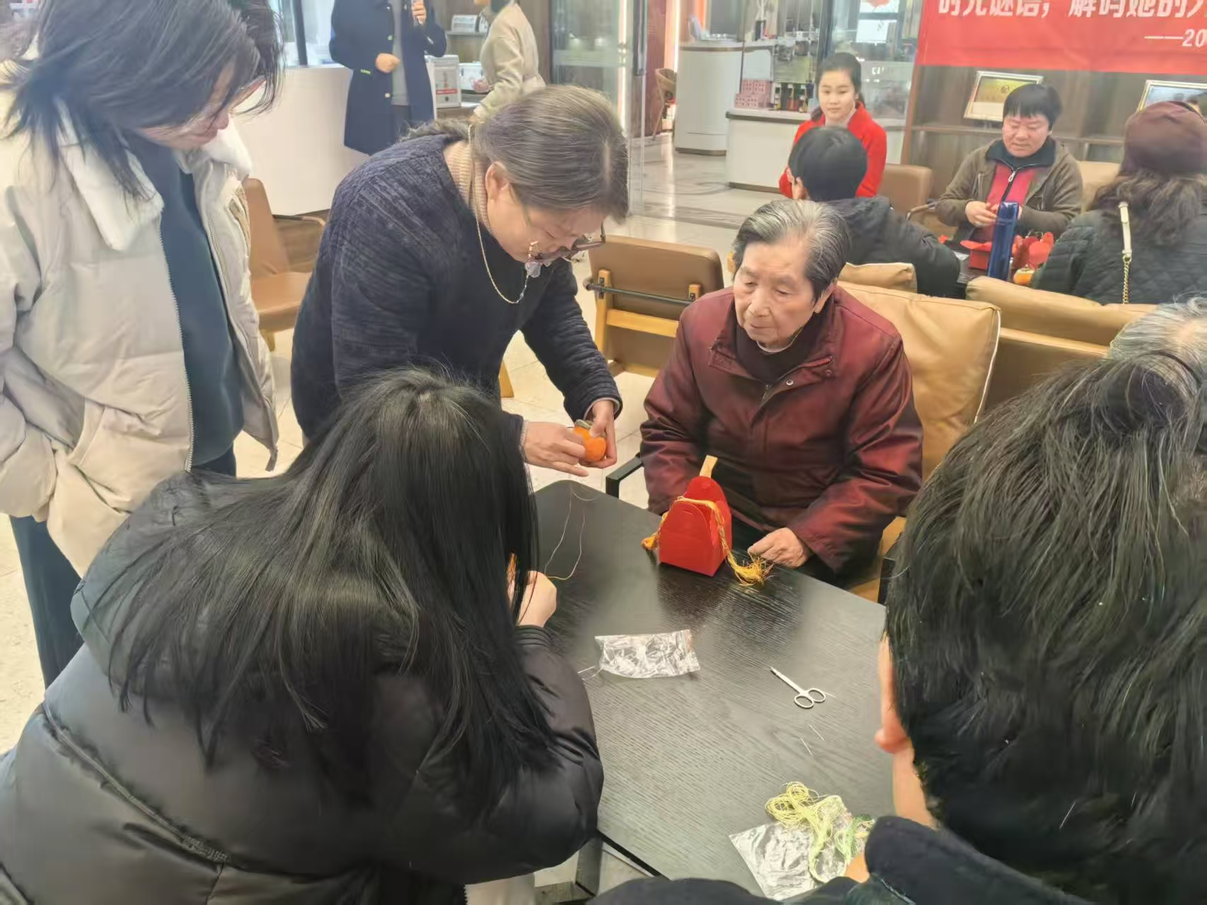 1741765775538153.jpg 1.汪老师帮助游客完成刺绣.jpg